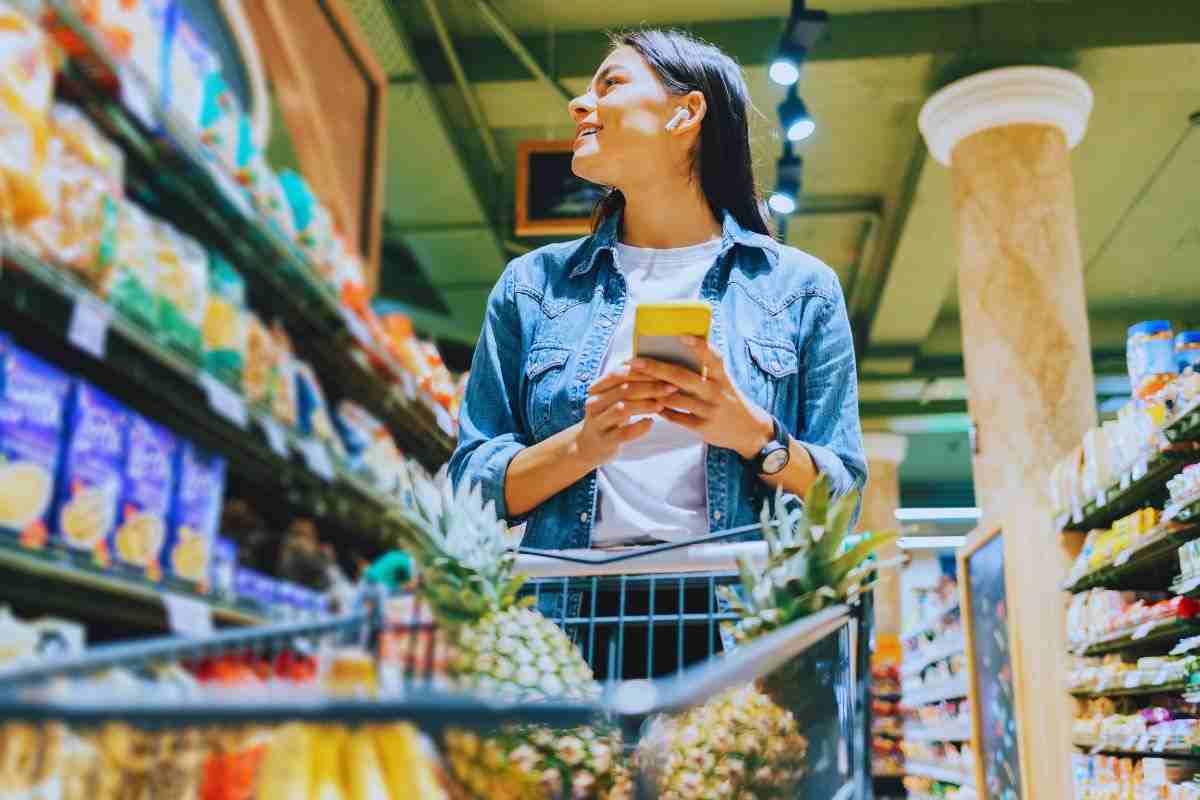 Donna che controlla i prezzi dei prodotti sugli scaffali