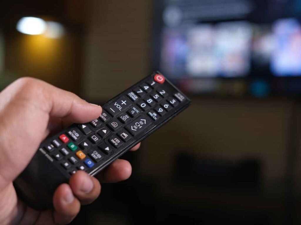 Persona che accende tv con telecomando