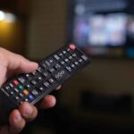 Persona che accende tv con telecomando
