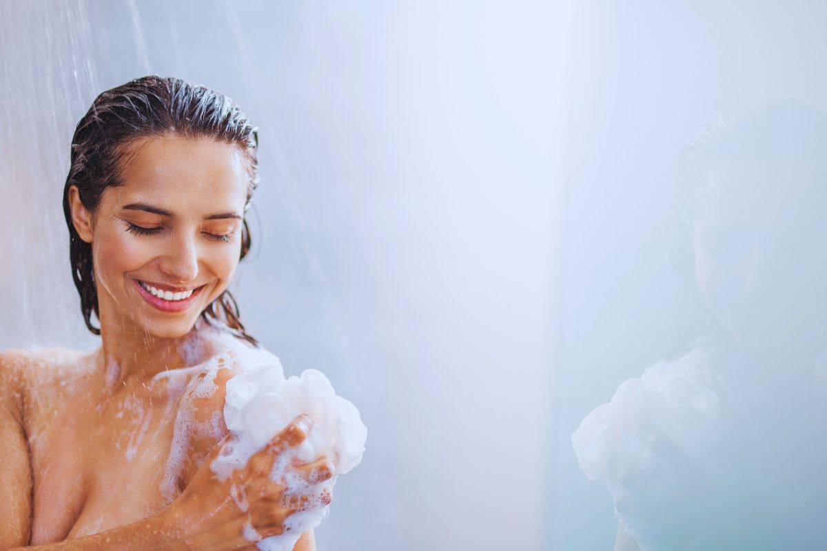 Donna che s'insapona sotto la doccia