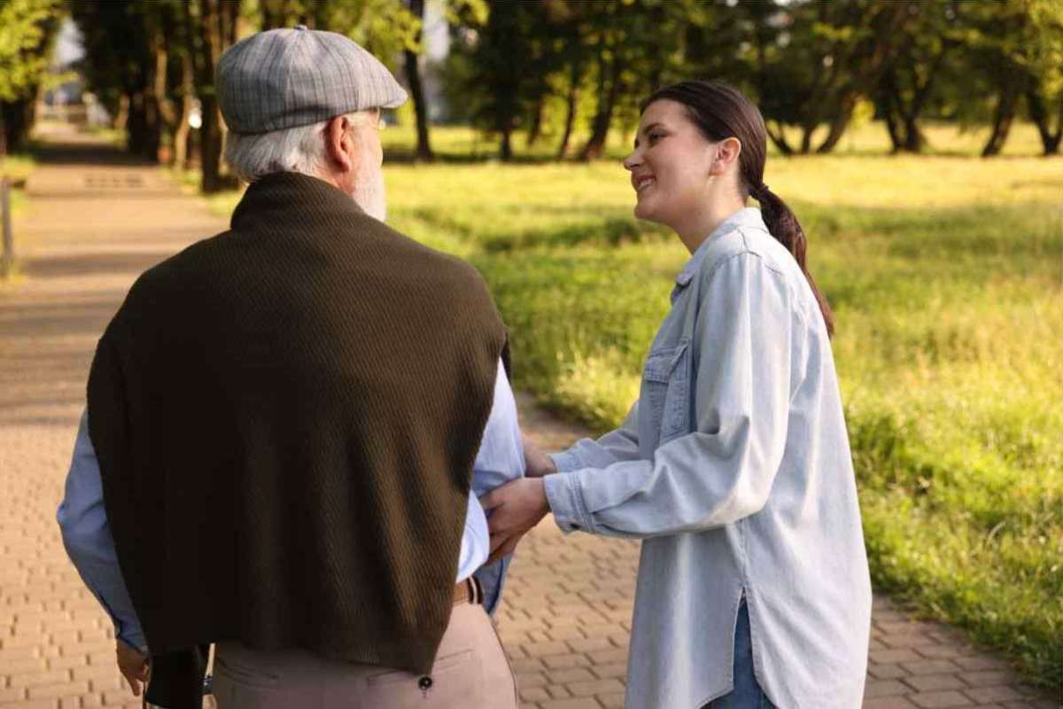 Donna sorridente passeggia accanto ad un anziano