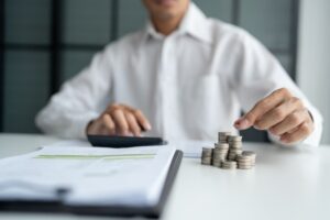 uomo che fa calcoli e monete