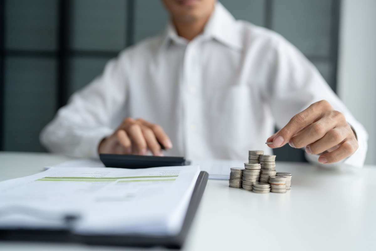 uomo che fa calcoli e monete