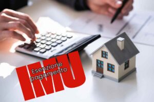 Modellino casa, calcolatrice e scritta "esenzione pagamento IMU"