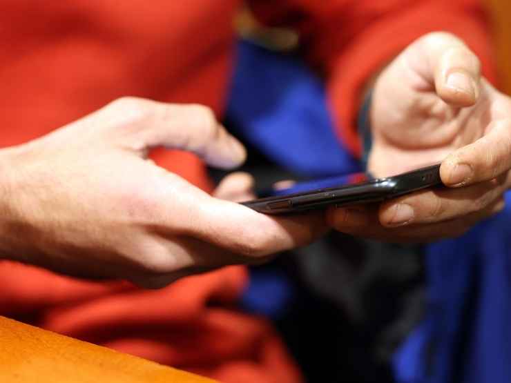 Una persona guarda il proprio cellulare