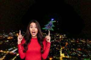 donna stupita che indica un grosso albero di natale