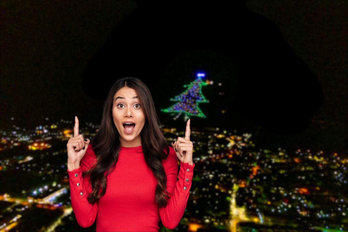 donna stupita che indica un grosso albero di natale 