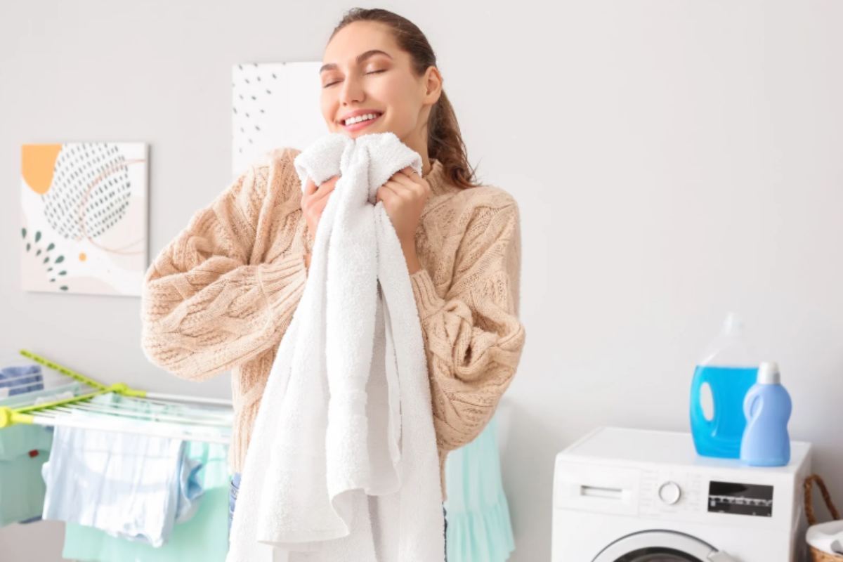 donna che stringe un asciugamano bianco morbido