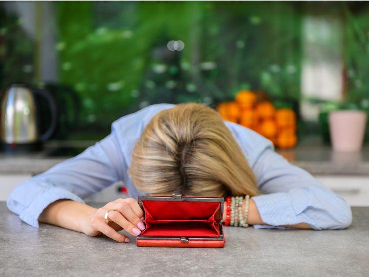 donna disperata che mostra un portafogli vuoto