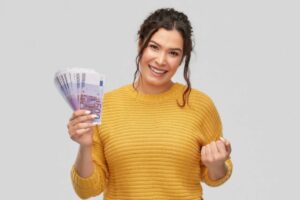 donna sorridente con in mano tante banconote da 500 euro