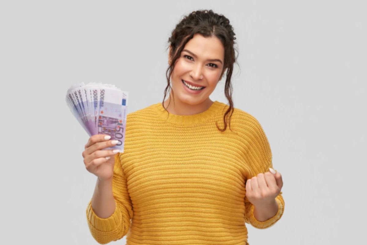 donna sorridente con in mano tante banconote da 500 euro