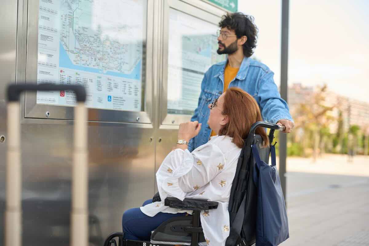 donna in carrozzella e uomo in piedi