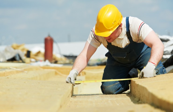 operaio che installa il materiale isolante