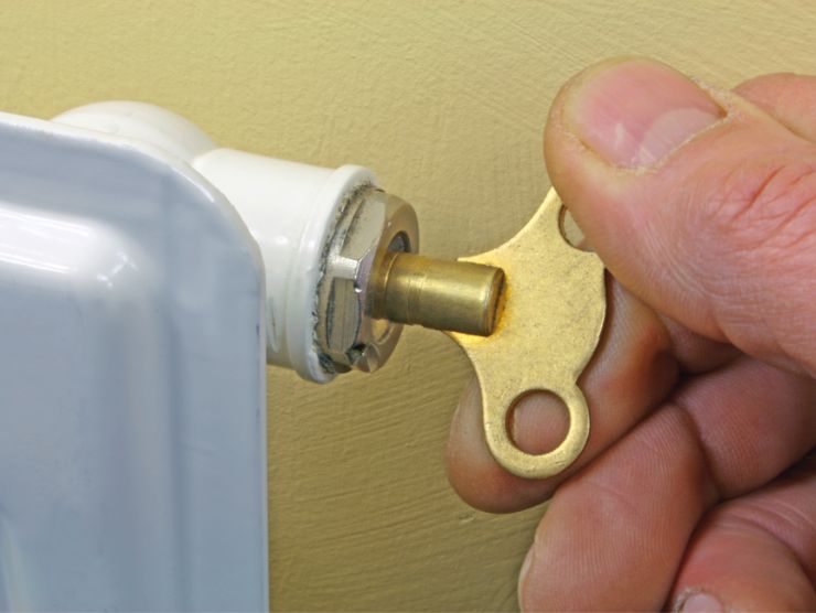 mano che gira valvola per lo spurgo del termosifone