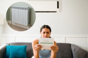 una persona che legge una bolletta e un termosifone vicino