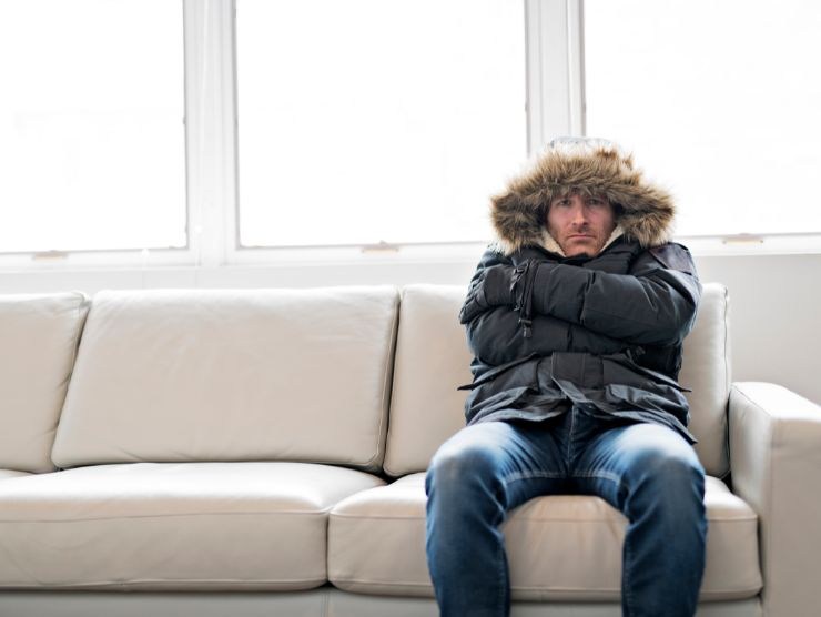 uomo infreddolito sul divano