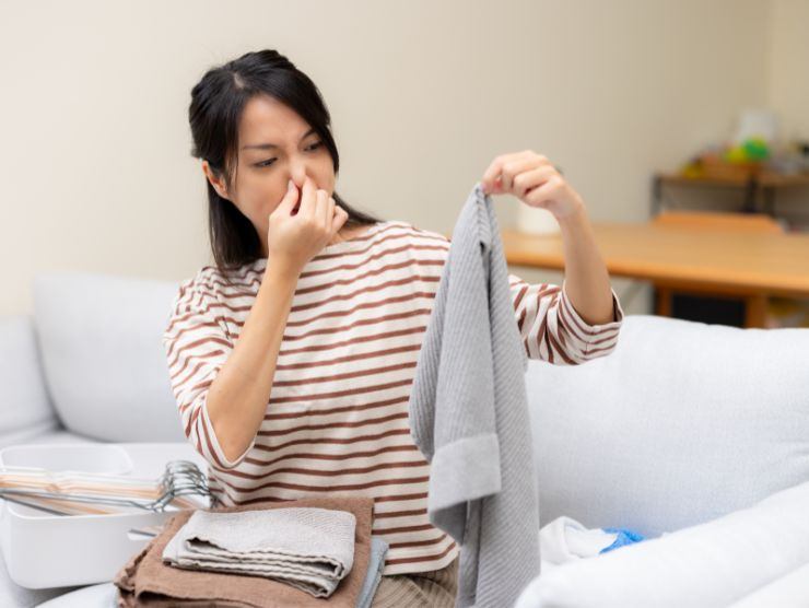 donna che ha in mano asciugamano che puzza