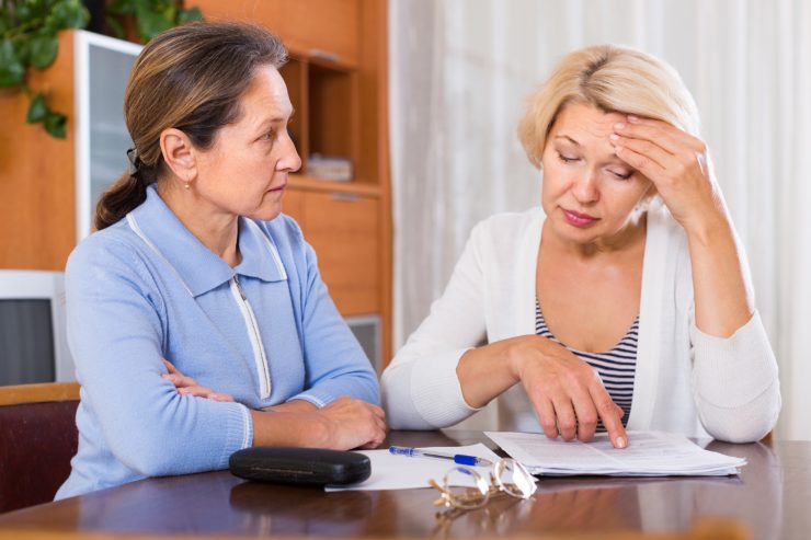 donna controlla documento e altra donna la osserva