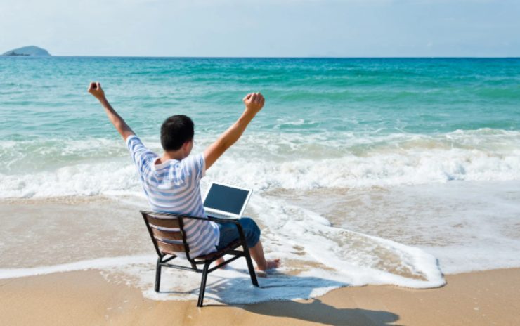 uomo che lavora al computer dalla spiaggia