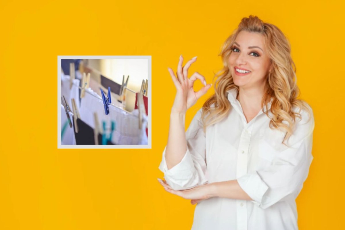 donna che sorride e fa ok con le dita e bucato steso 