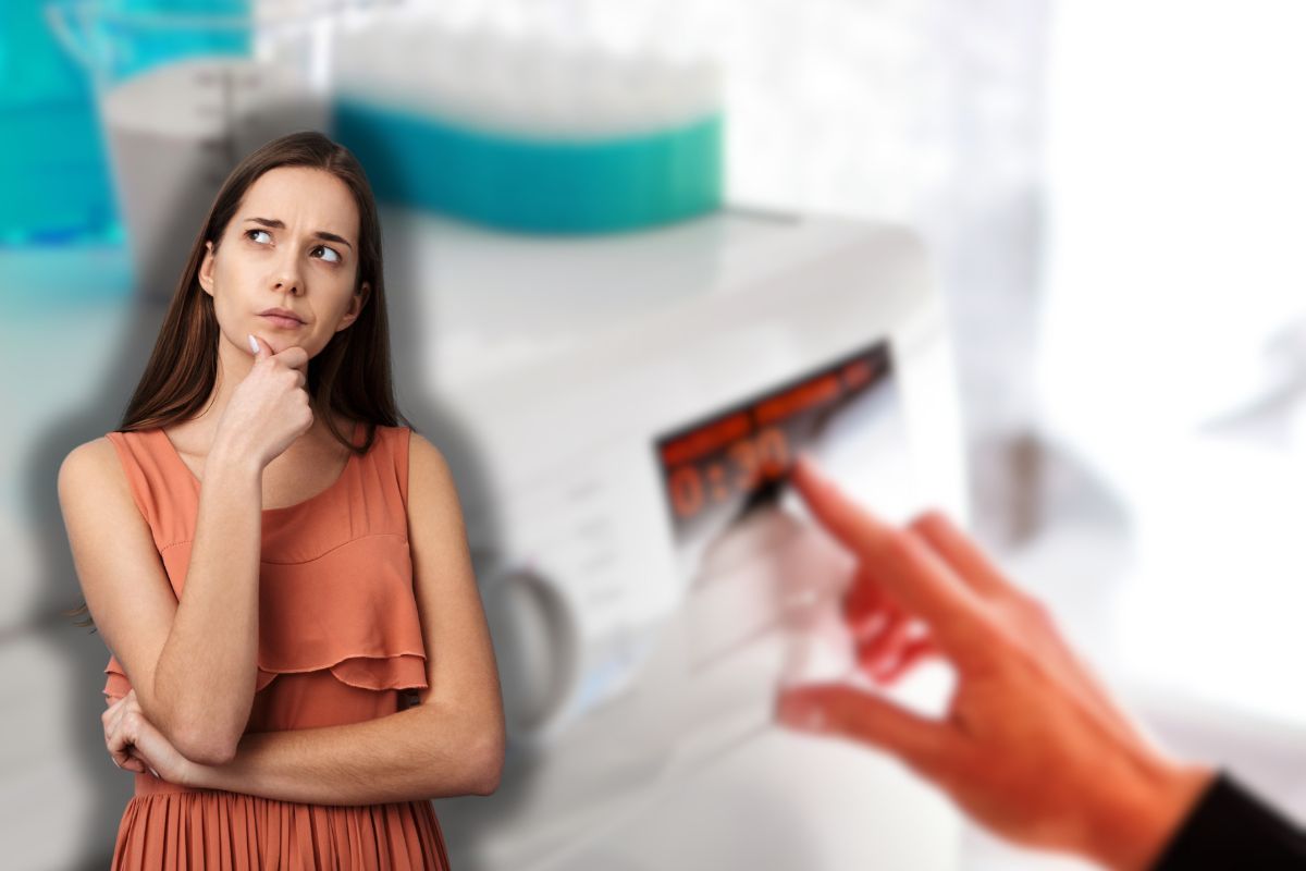 donna che seleziona lavaggio in lavatrice e un'altra che pensa 