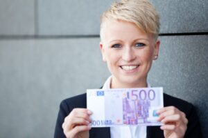 donna che sorride con in mano una banconota da 500 euro