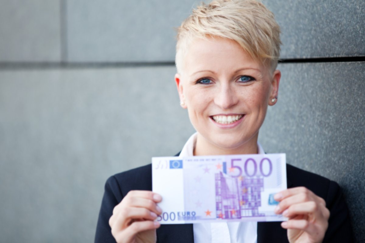 donna che sorride con in mano una banconota da 500 euro