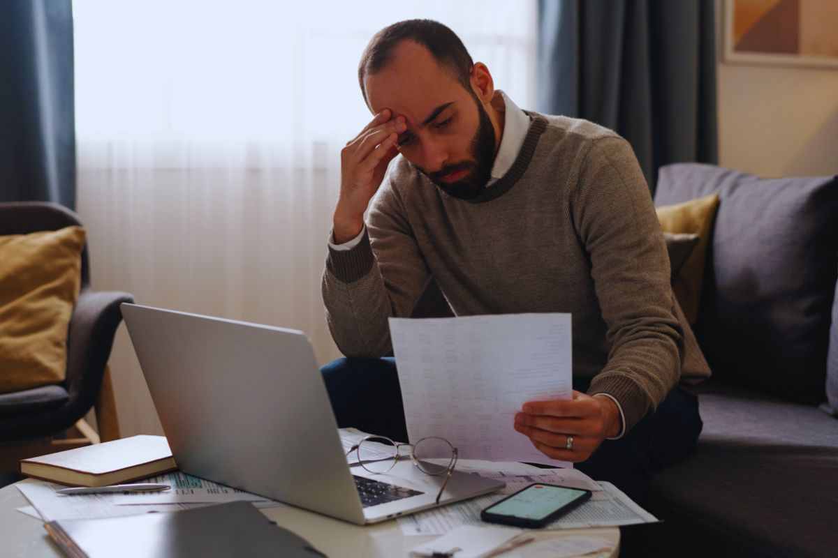 Uomo preoccupato con documento in mano