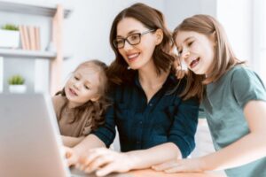 mamma davanti al computer con accanto due bambine