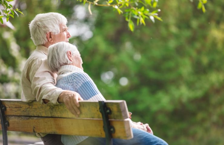 coppia di anziani seduti su una panchina al parco