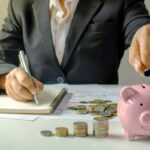 uomo che scrive su un quaderno e onete