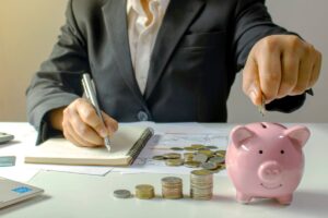 uomo che scrive su un quaderno e onete