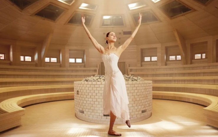donna che danza dentro ad una sauna di legno