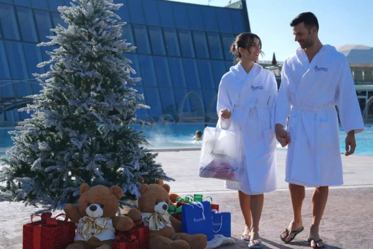 coppia all'interno del parco termale e accanto un albero di natale