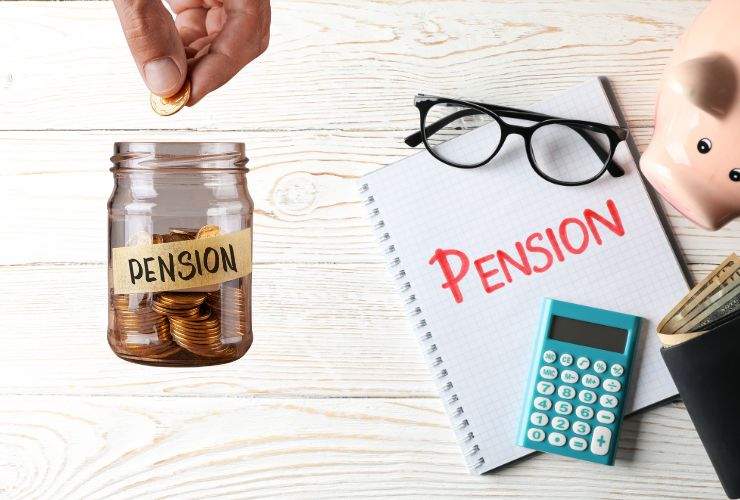 degli occhiali, un quaderno e una calcolatrice. vicino un barattolino con dei soldi dentro