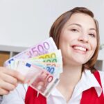 donna che sorride con in mano tante banconote di euro