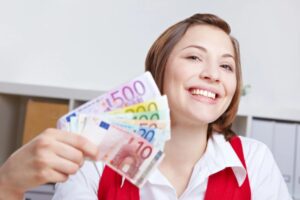donna che sorride con in mano tante banconote di euro