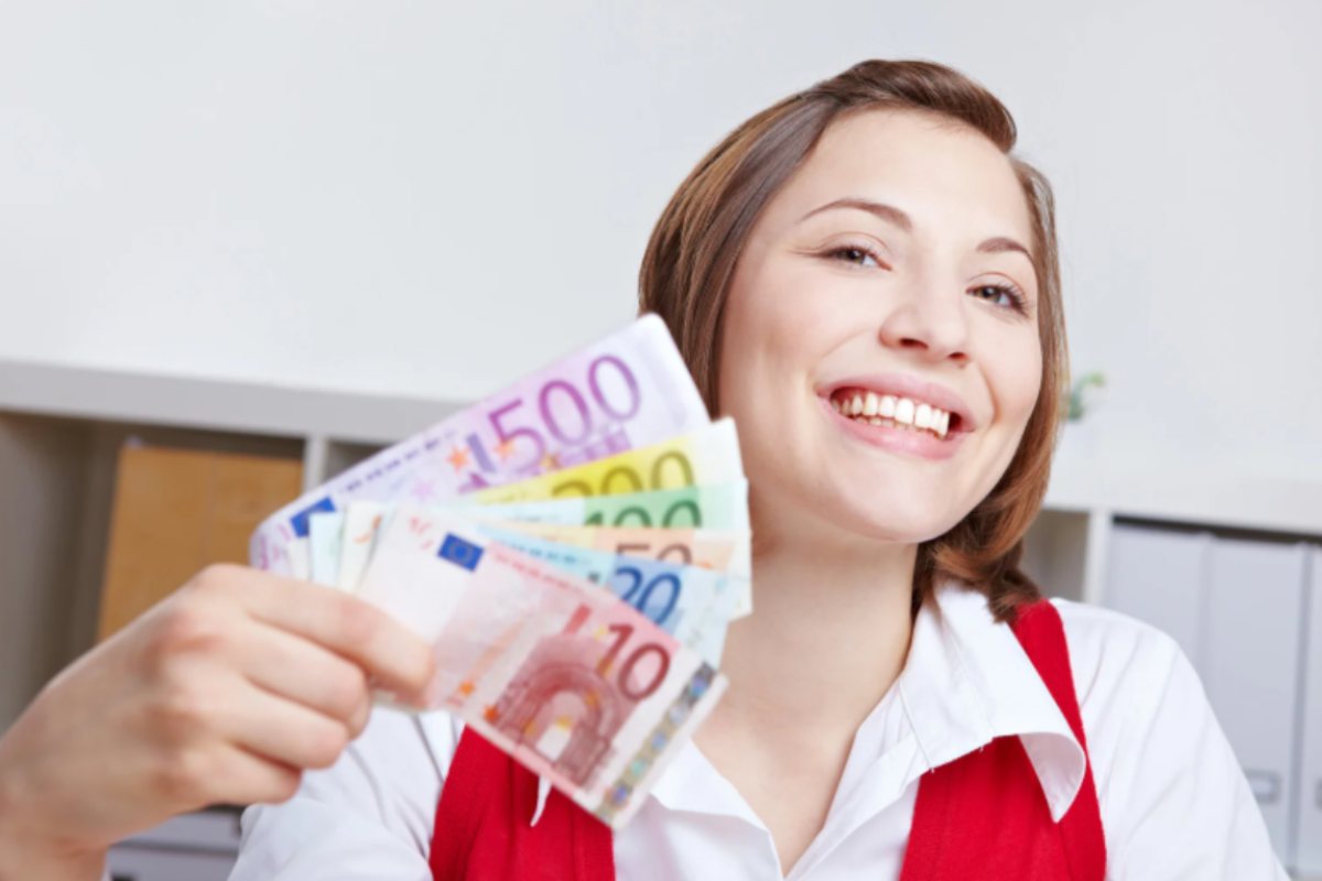 donna che sorride con in mano tante banconote di euro